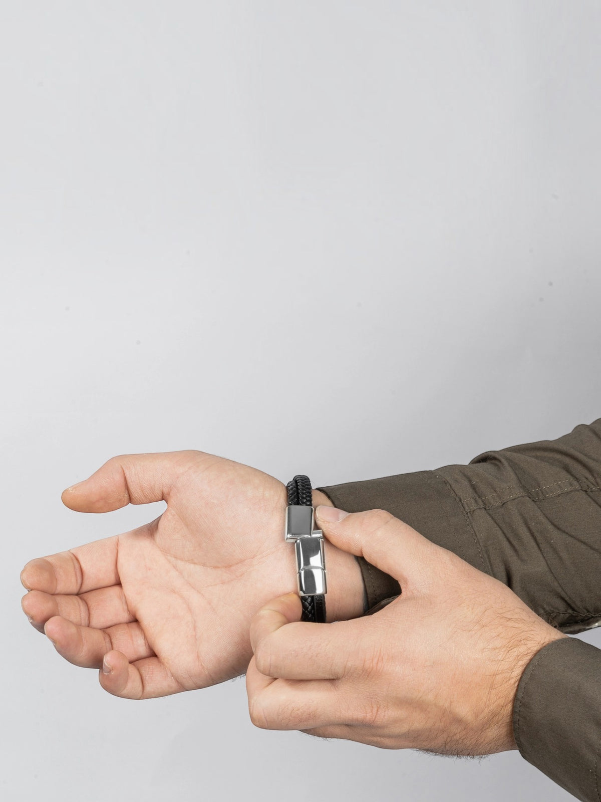 BROCK SERASAR black braided leather bracelet with a silver stainless steel magnetic clasp worn on a man's wrist