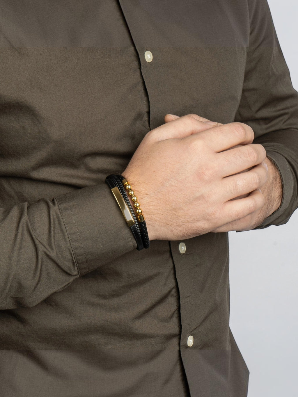 BROCK SERASAR black leather and gold bead bracelet with a magnetic stainless steel clasp worn on a man's wrist