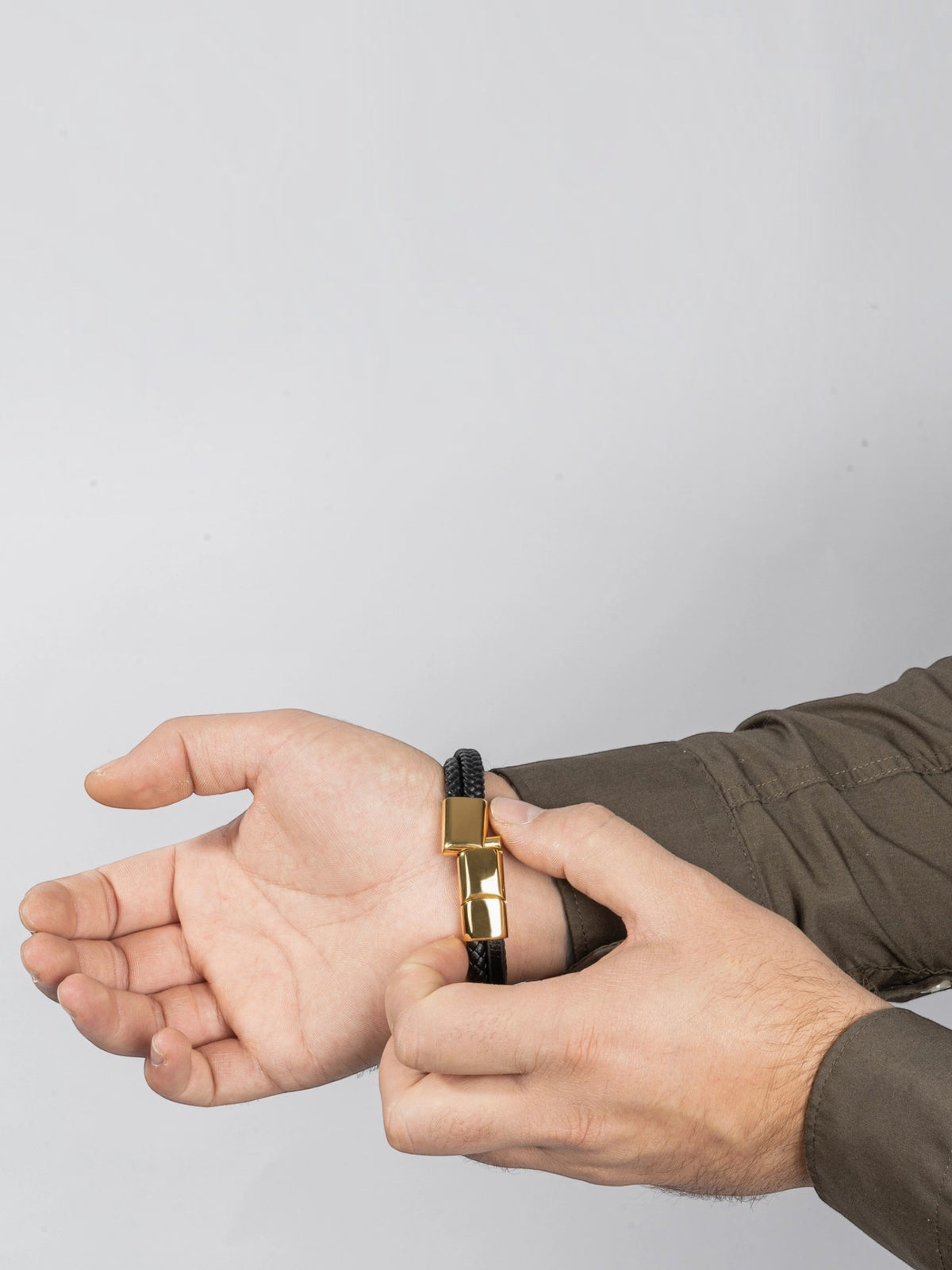 BROCK SERASAR black leather bracelet with a gold magnetic stainless steel clasp worn on a man's wrist