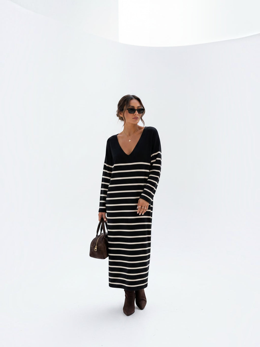 BROCK striped maxi dress with V-neck and long sleeves worn by a woman with sunglasses and a brown handbag