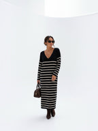 BROCK striped maxi dress with V-neck and long sleeves worn by a woman with sunglasses and a brown handbag