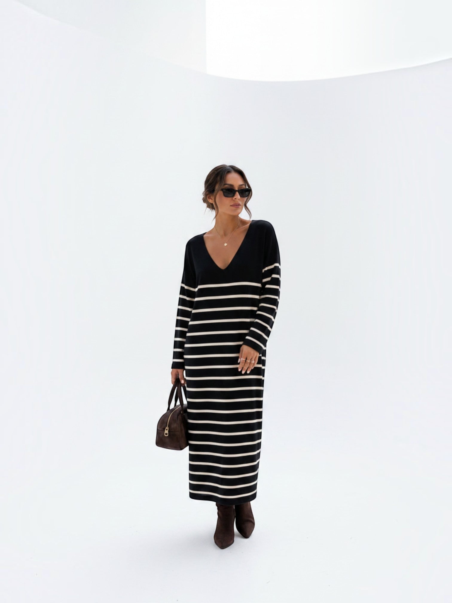 BROCK striped maxi dress with V-neck and long sleeves worn by a woman with sunglasses and a brown handbag