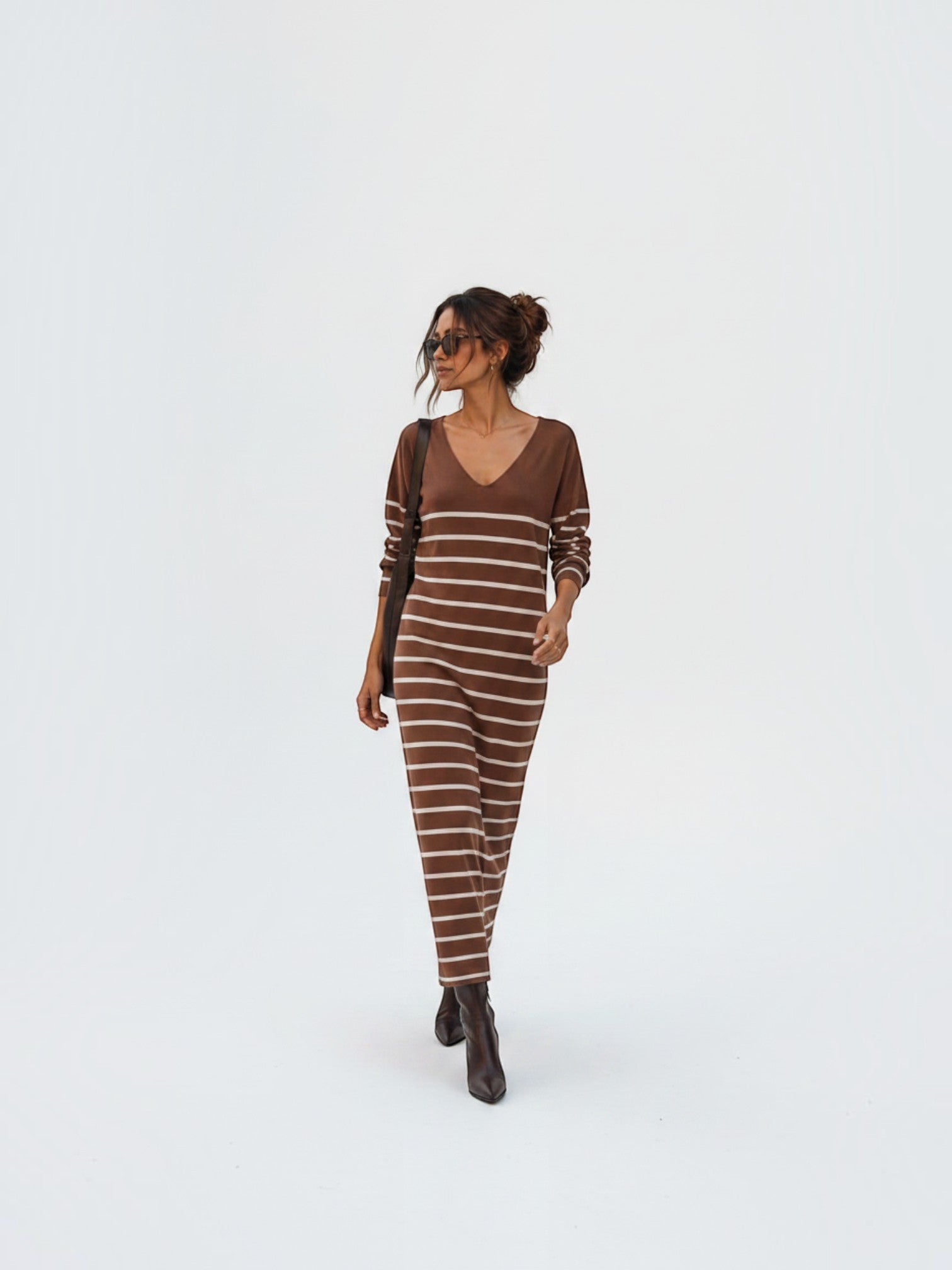 Model wearing a BROCK long-sleeved maxi dress with brown and white stripes and a V-neck, styled with brown boots.