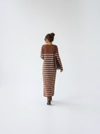 BROCK long striped maxi dress with V-neck and long sleeves worn by a woman with a brown shoulder bag
