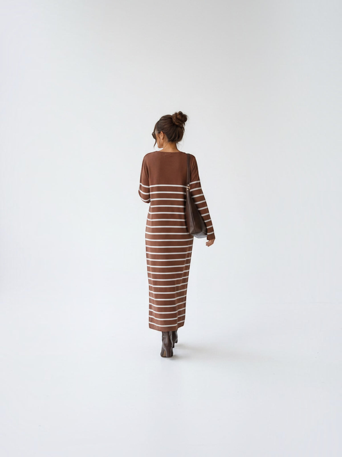 BROCK long striped maxi dress with V-neck and long sleeves worn by a woman with a brown shoulder bag