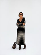 BROCK long striped maxi dress with V-neck and long sleeves worn by a model with sunglasses and brown boots