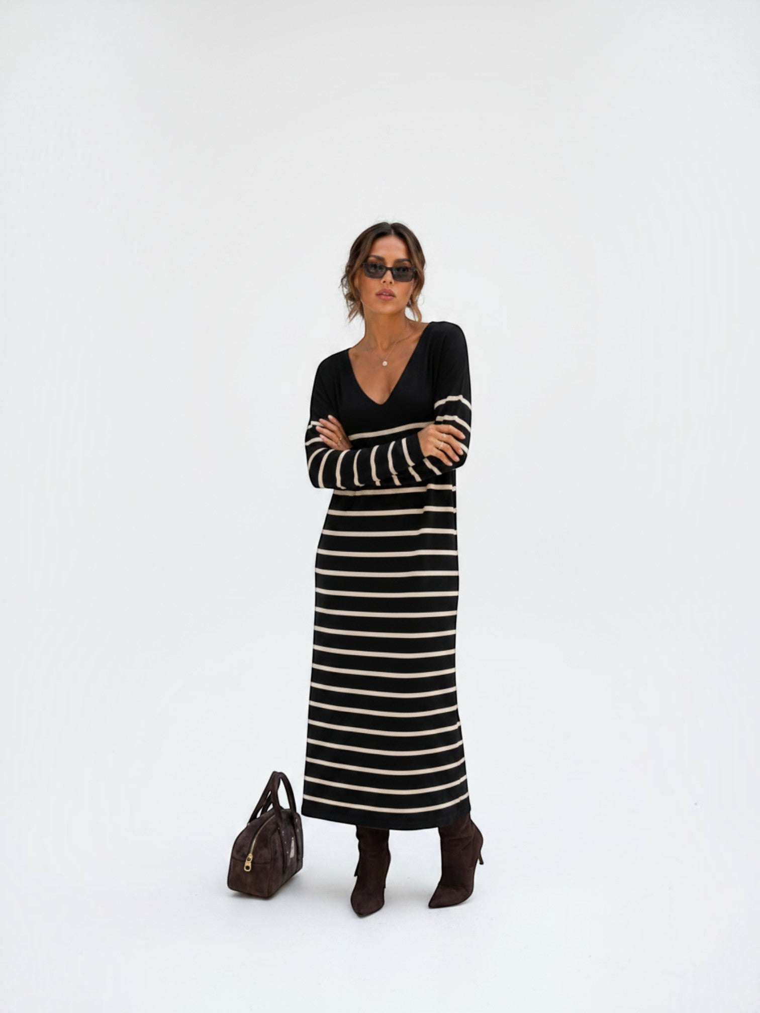 BROCK long striped maxi dress with V-neck and long sleeves worn by a model with sunglasses and brown boots