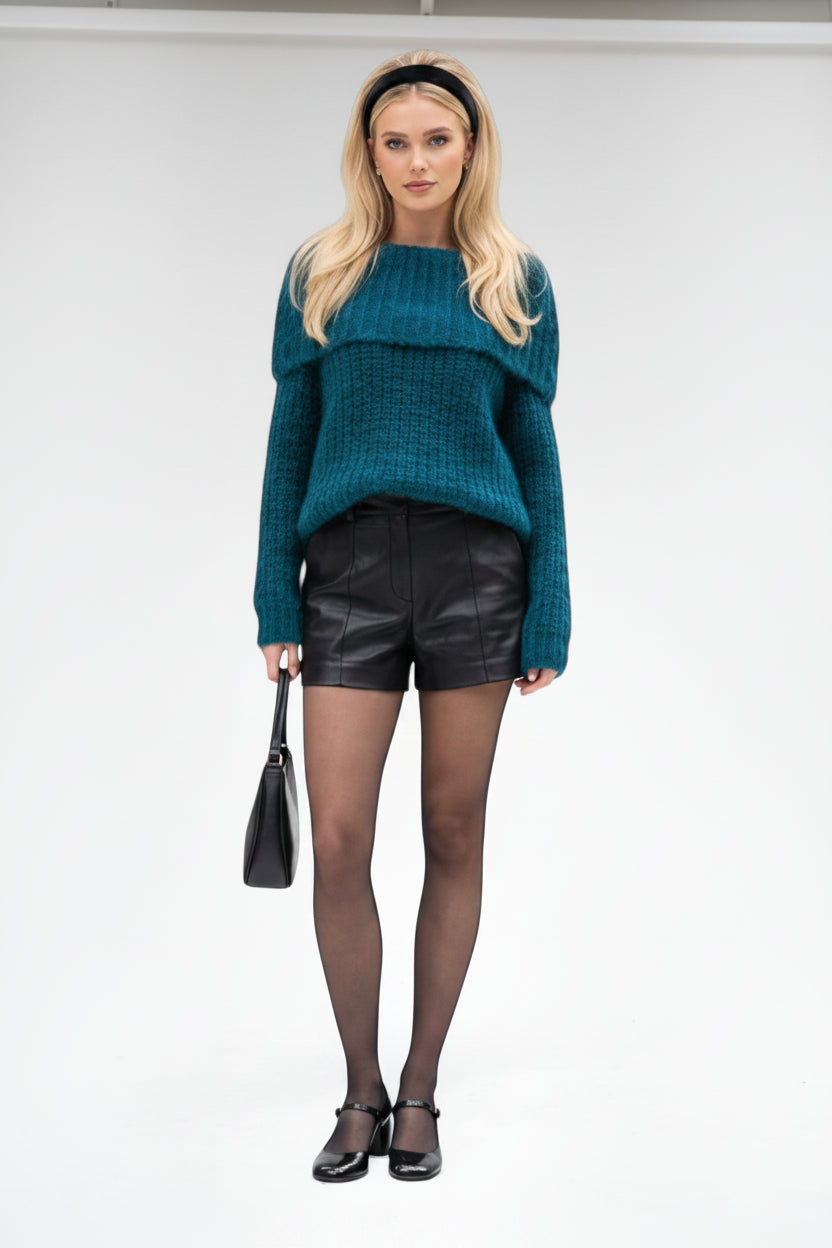 Model wearing a BROCK teal blue textured bardot sweater with black leather shorts, tights, and a black headband.
