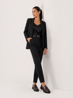 Model wearing BROCK two-tone chunky loafers with a black blazer and trousers in a minimalist studio setting
