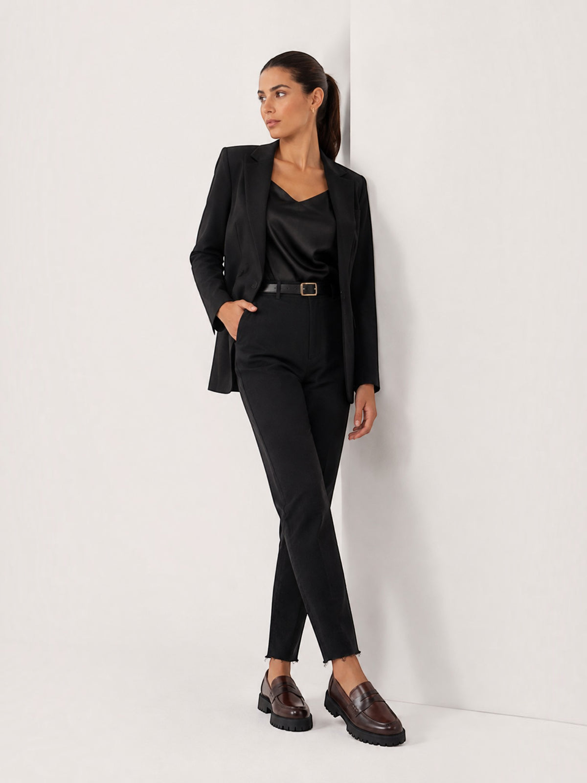 Model wearing BROCK two-tone chunky loafers with a black blazer and trousers in a minimalist studio setting