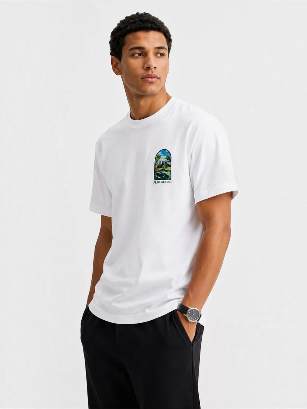BROCK white cotton t-shirt with short sleeves and a small artistic graphic print on the chest, worn by a man.