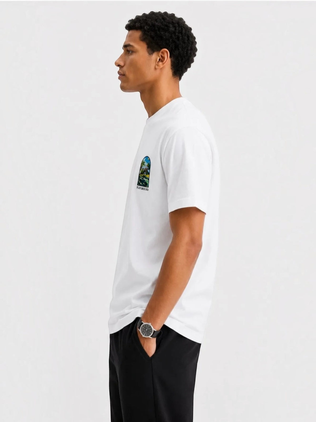 BROCK white cotton t-shirt with a small graphic print on the chest, worn by a man in a side profile view.