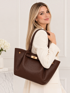 BROCK Yara brown leather tote bag with gold hardware carried by a woman in a white blazer