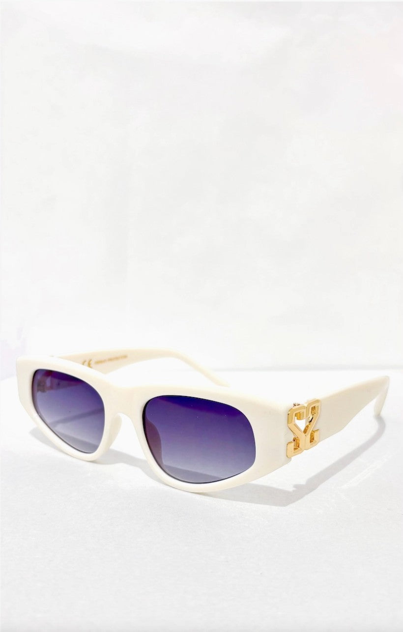 Lunettes de soleil ÉLINE L'ATELIER blanches avec logo doré, monture épaisse et verres dégradés violets.