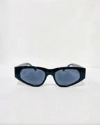 Lunettes de soleil ÉLINE L'ATELIER noires, monture épaisse et verres gris fumé, design géométrique audacieux.