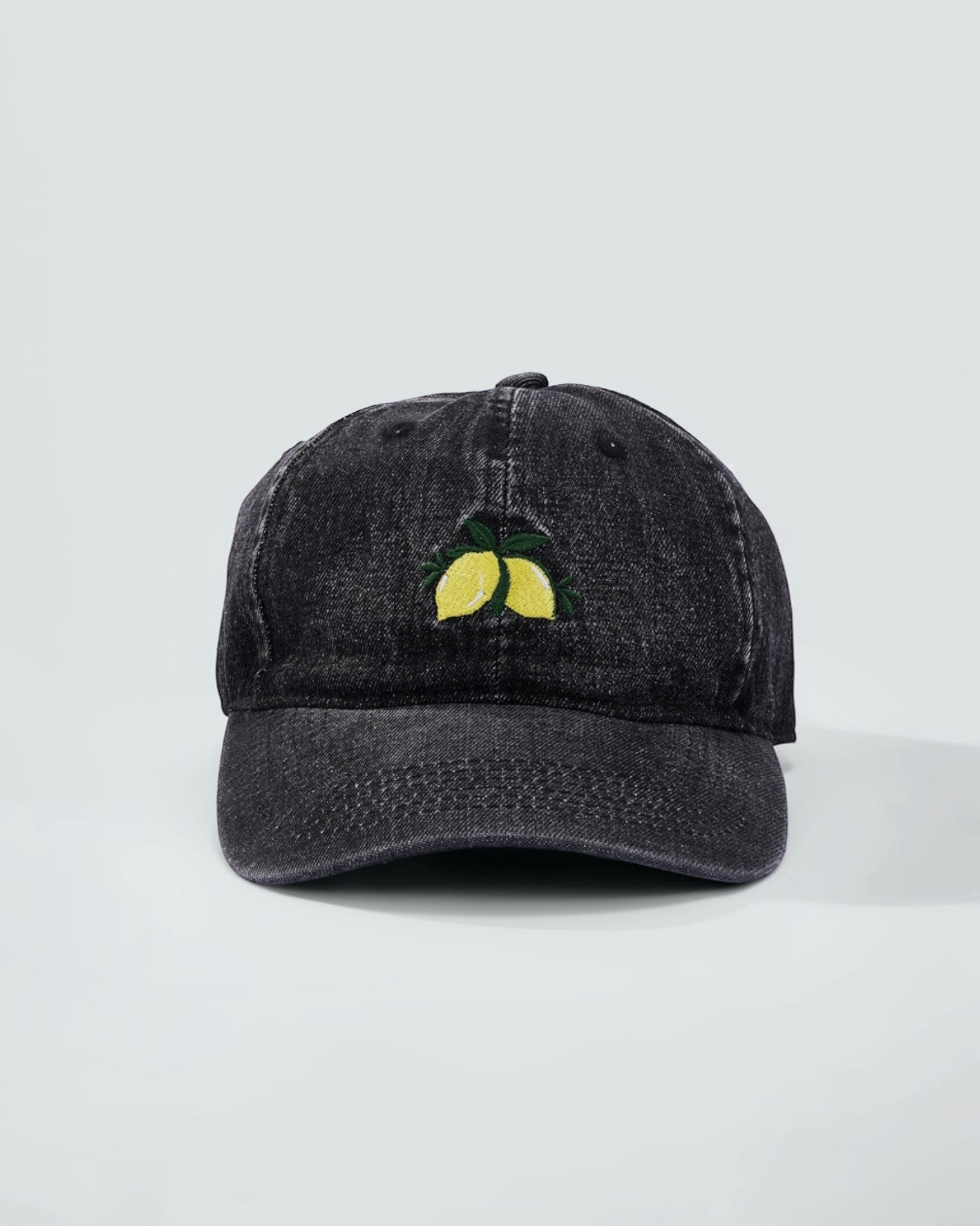 Casquetten coton noir avec broderie de citrons jaunes et feuilles vertes sur le devant.