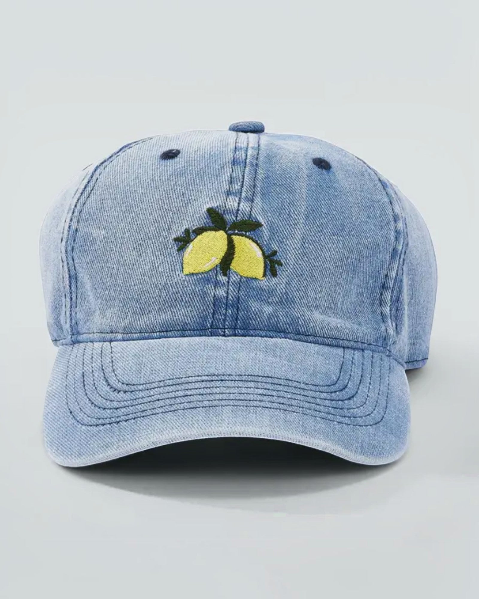 Casquette en coton bleu jean avec broderie de citrons jaunes à l'avant.