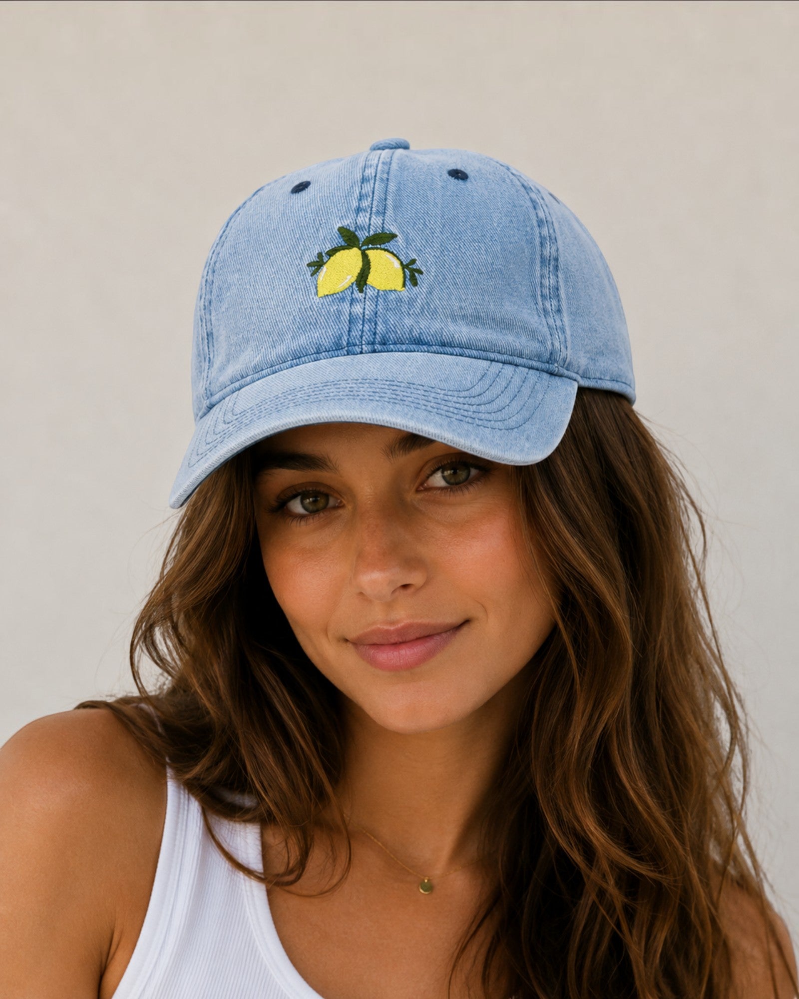 Casquette en jean bleu clair avec broderie de citrons jaunes et feuilles vertes sur le devant. Coton.
