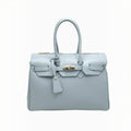 Grand sac à main professionnel  en cuir grainé bleu ciel avec fermoir doré et anses structurées.