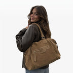 Femme portant le sac à main LOUISA LEE Big Gabrielle en cuir suède marron avec bandoulière sur l'épaule
