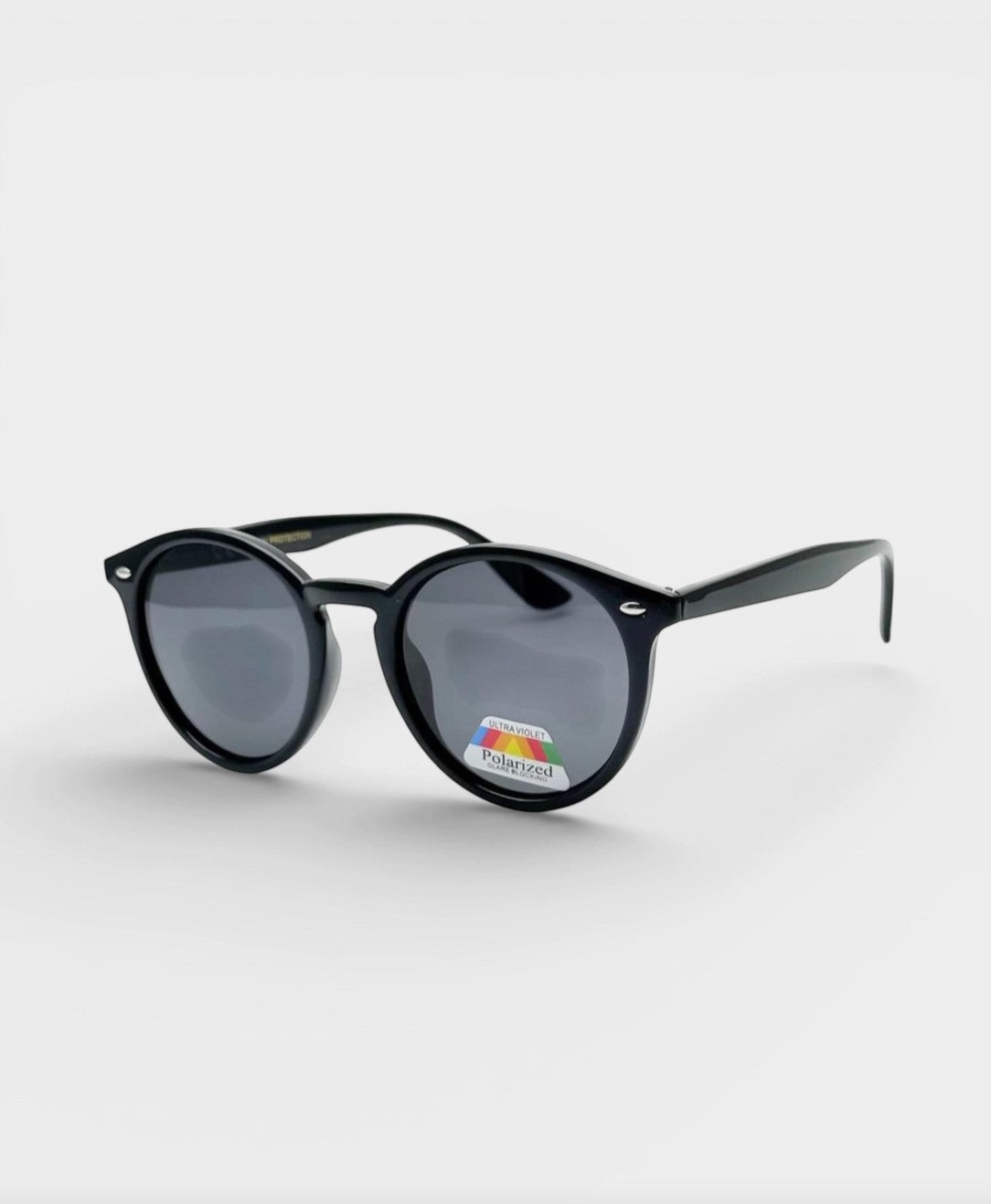 Lunettes de soleil ÉLINE L'ATELIER noires, monture ronde en plastique, verres polarisés et protection UV.