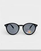 Lunettes de soleil ÉLINE L'ATELIER noires rondes avec verres polarisés et protection UV. Monture en acétate.