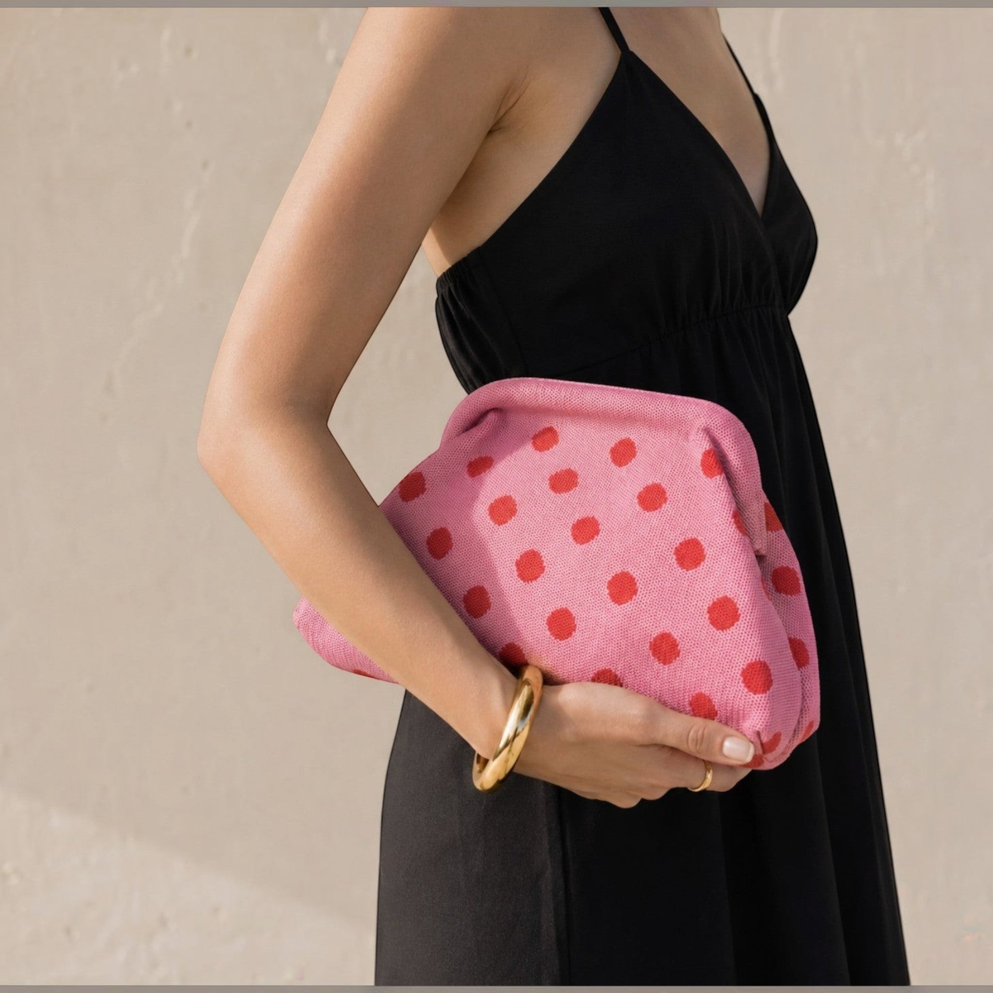 Pochette à pois Simon LOUISA LEE rose et rouge portée à la main, vendue par design textile souple et chic.