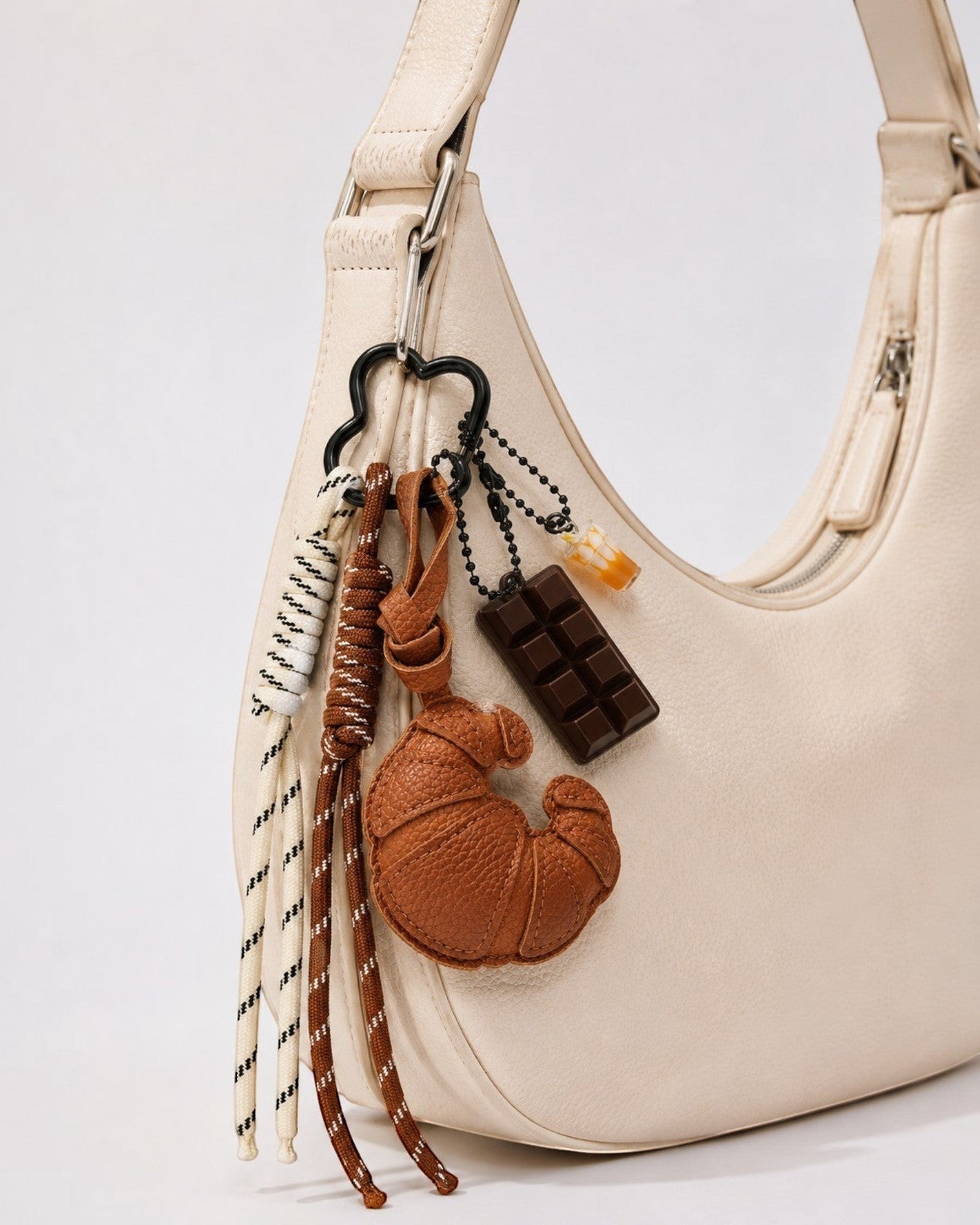 Porte-clés fantaisie avec breloques croissant en cuir marron, tablette de chocolat et tasse. Cordons tressés.