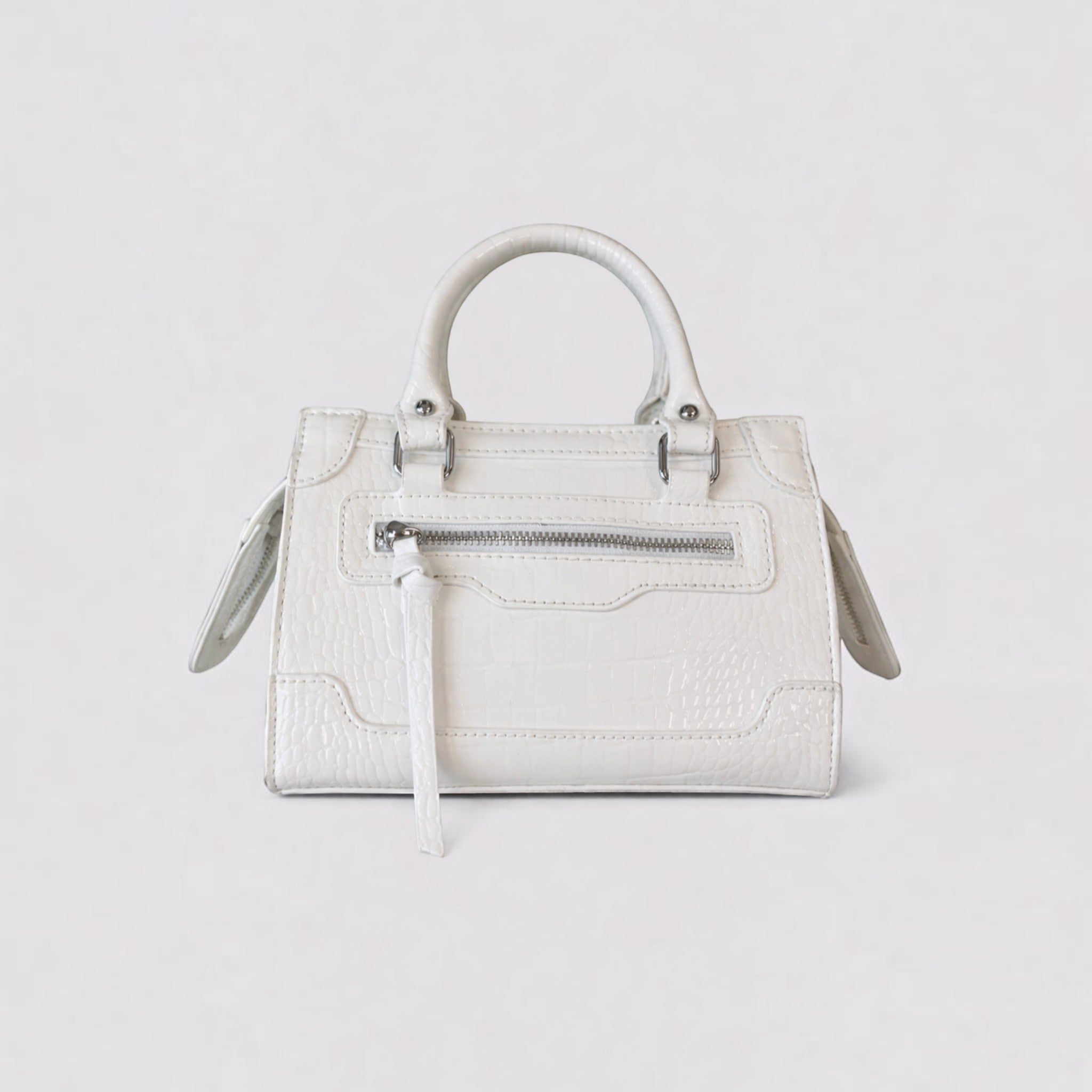 Sac à main structuré blanc effet croco avec poignées, fermeture éclair frontale et détails argentés.