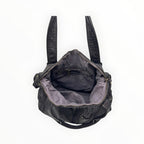 Sac à main en cuir noir avec détails tressés, anses robustes, bandoulière et intérieur spacieux zippé.