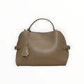 Sac à main  taupe en cuir structuré avec poignée ergonomique et détails métalliques discrets.