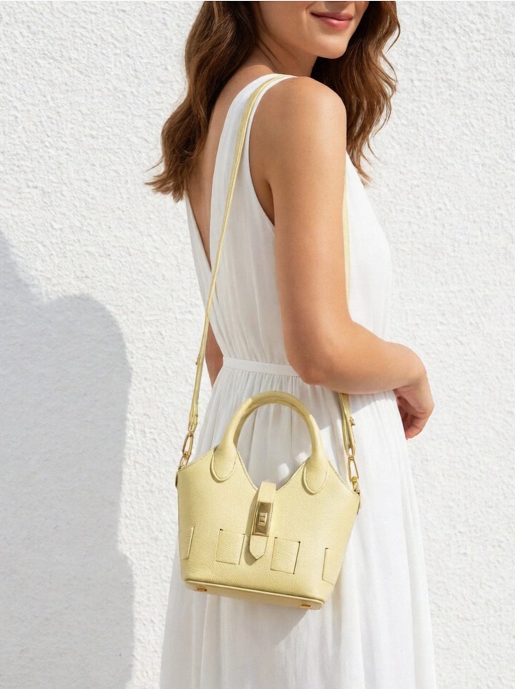 Sac bandoulière SUIE VALENTINI en cuir jaune pâle porté par une femme en robe blanche, fabrication italienne.