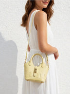 Sac bandoulière SUIE VALENTINI en cuir jaune pâle porté par une femme en robe blanche, fabrication italienne.