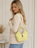 Femme portant un sac bandoulière SUIE VALENTINI en cuir jaune, fabriqué à la main en Italie avec détails tressés.