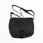 Sac bandoulière  en cuir noir tressé avec bandoulière réglable et détails en métal vieilli.