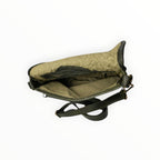 Intérieur du sac bandoulièreen cuir tressé vert olive avec doublure textile et fermeture zippée.