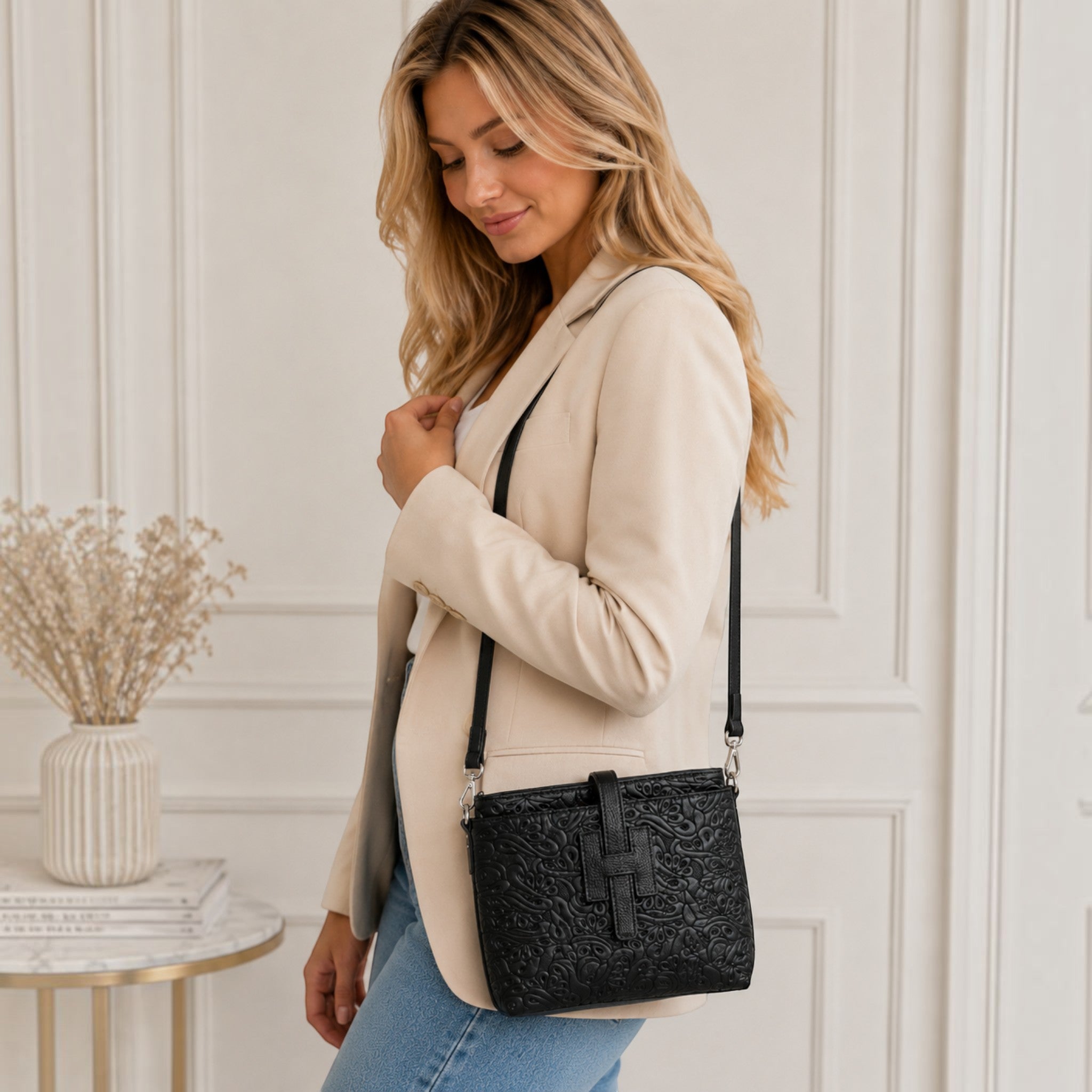 Femme portant un sac d'épaule SUIE VALENTINI en cuir noir imprimé, fabriqué à la main en Italie.