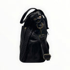 Sac à main en cuir noir avec détails tressés, anses et bandoulière réglable pour femme.