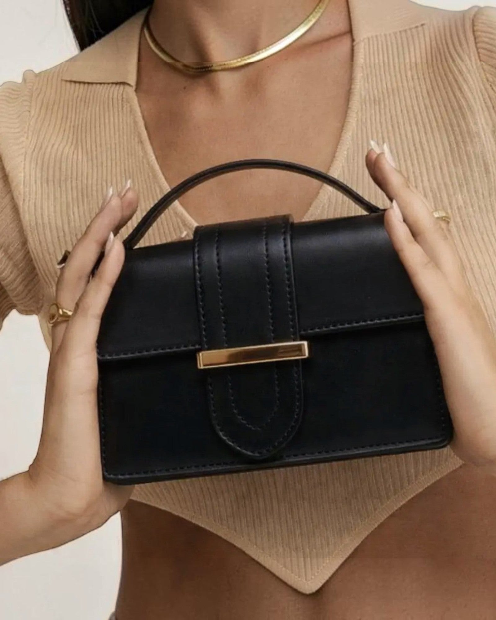 sac à main structuré noir en cuir lisse avec fermoir doré et poignée supérieure