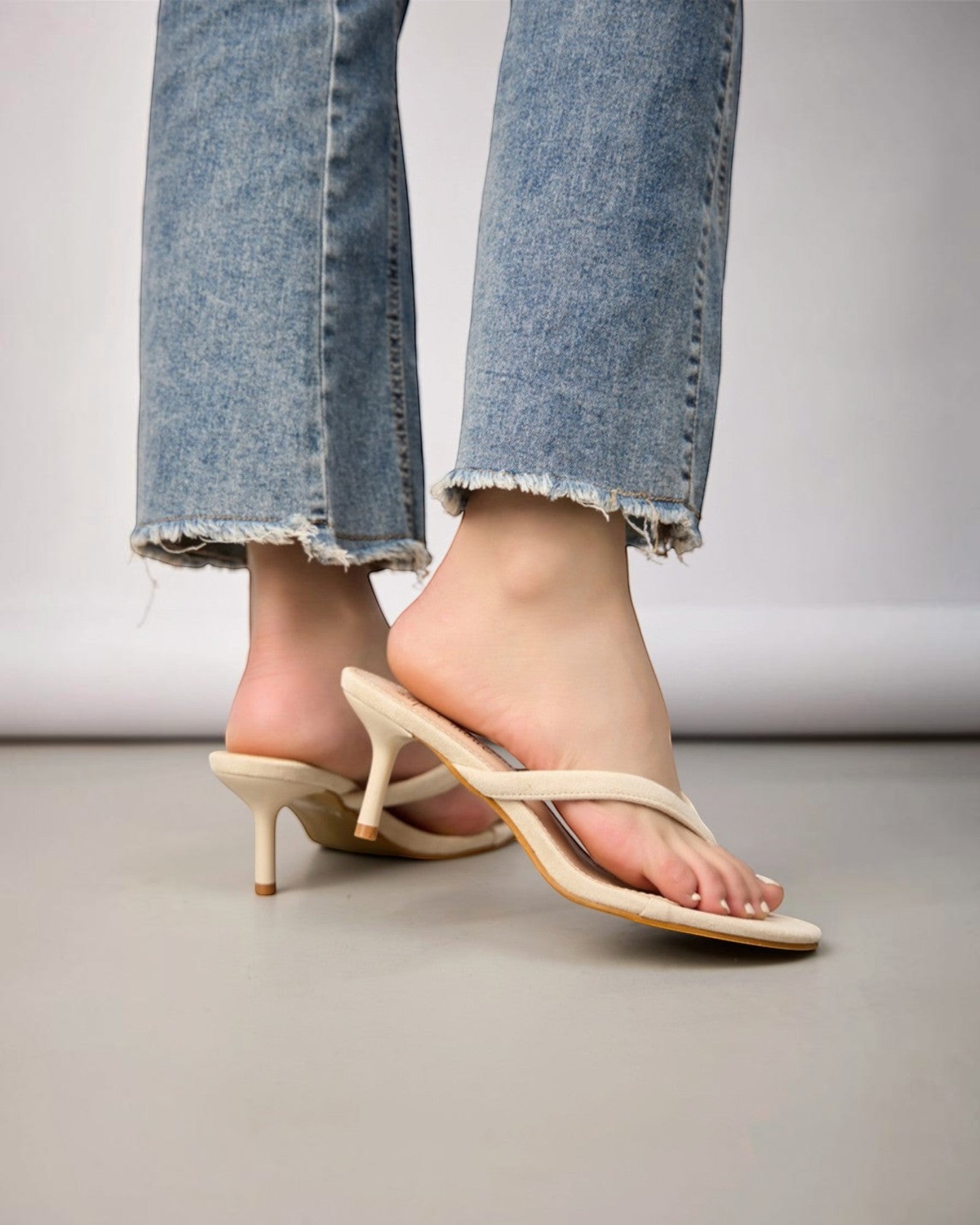 Sandales beige à talon fin et bout ouvert pour femme, en daim synthétique, avec bride entre les orteils.