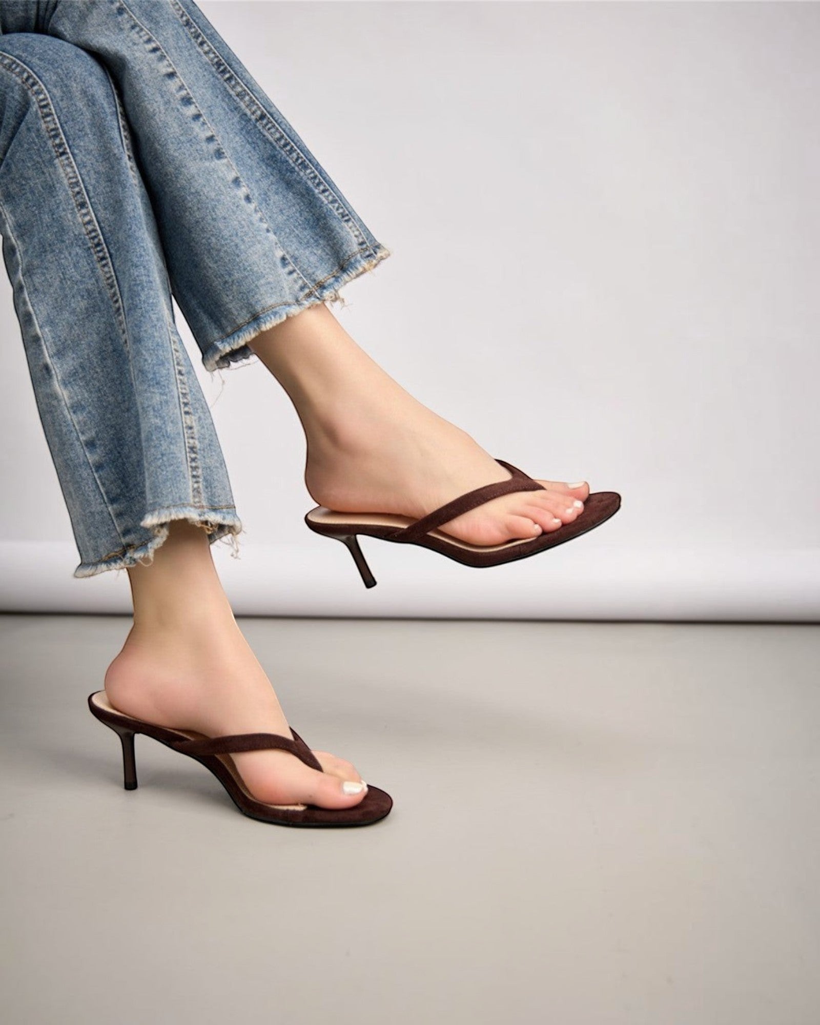 sandales marron à talon fin et bout ouvert, bride entre les orteils, style minimaliste.