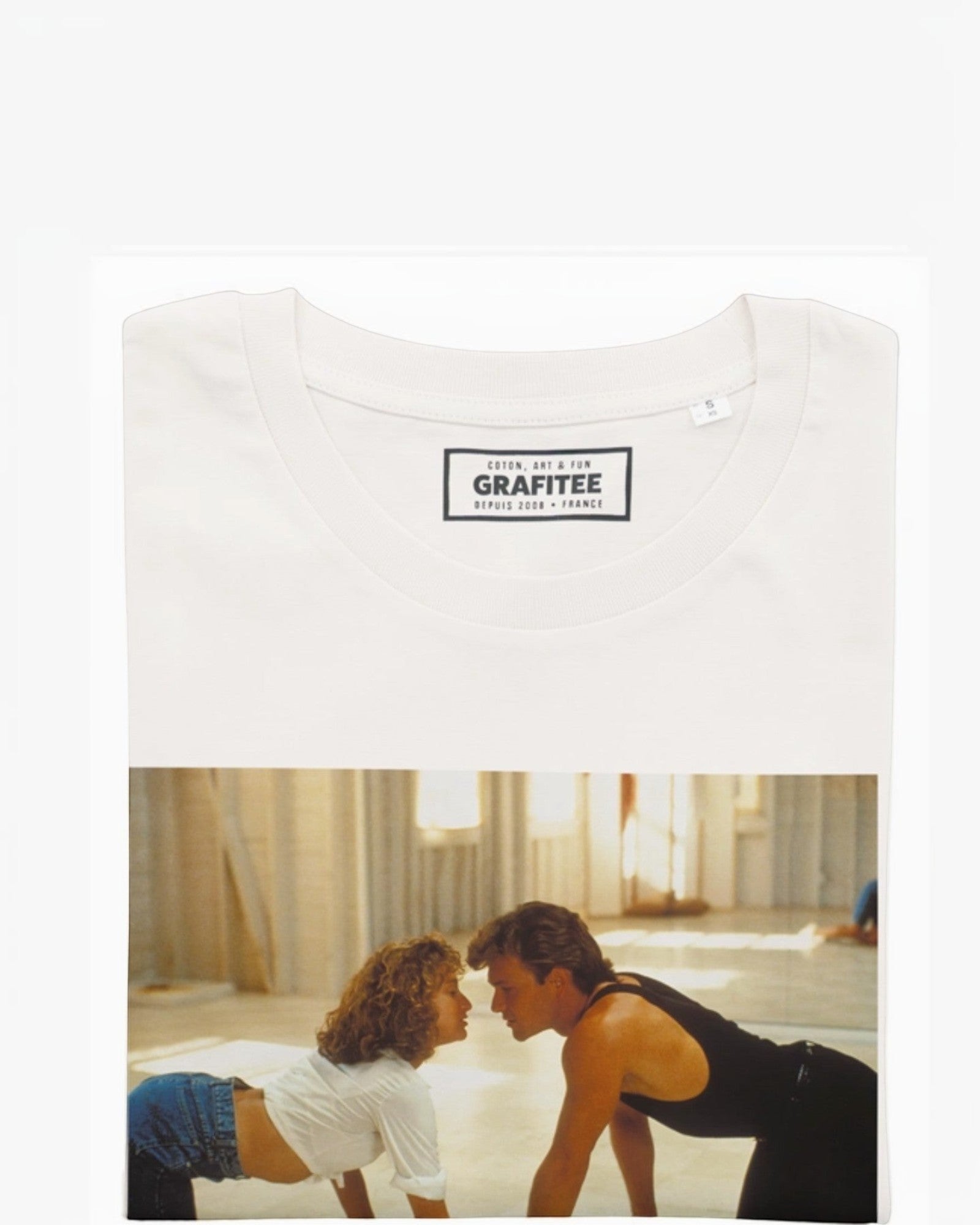 T-shirt blanc en coton bio avec un imprimé graphique de la scène iconique de Dirty Dancing. Manches courtes, col rond.